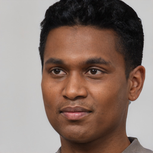Joyful black young-adult male with short  black hair and brown eyes