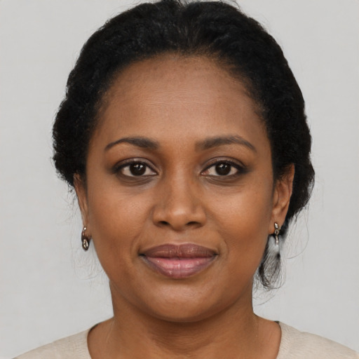 Joyful black young-adult female with short  black hair and brown eyes
