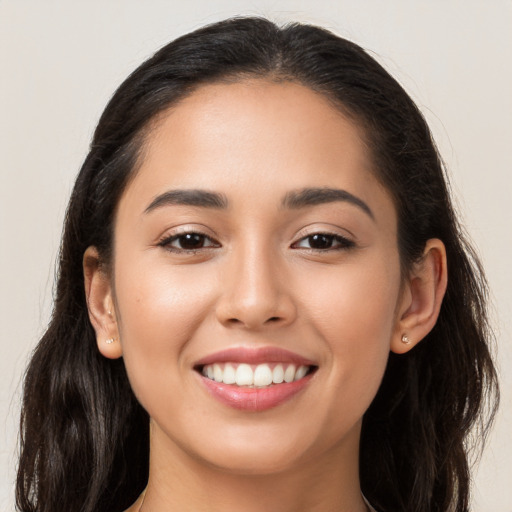 Joyful latino young-adult female with long  brown hair and brown eyes