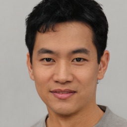 Joyful asian young-adult male with short  black hair and brown eyes