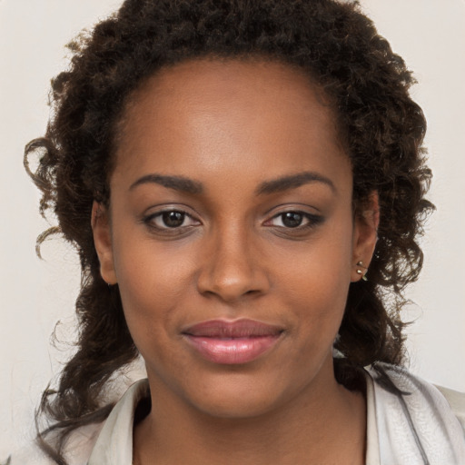 Joyful black young-adult female with long  brown hair and brown eyes