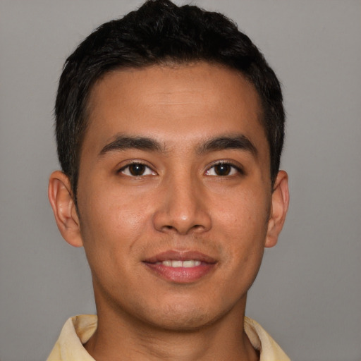 Joyful latino young-adult male with short  brown hair and brown eyes