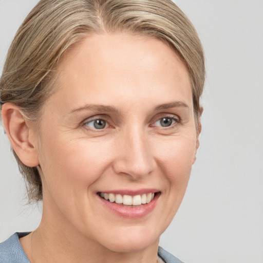 Joyful white adult female with medium  brown hair and grey eyes