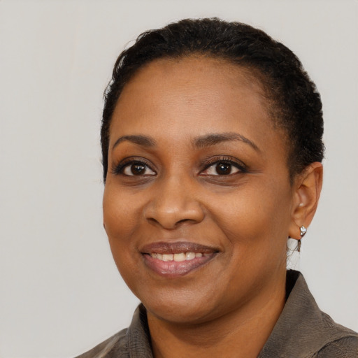 Joyful black young-adult female with short  black hair and brown eyes