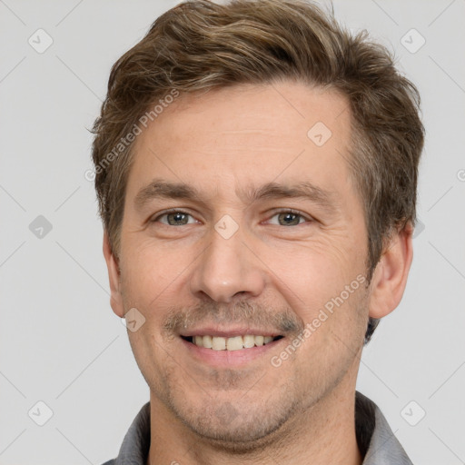 Joyful white adult male with short  brown hair and grey eyes