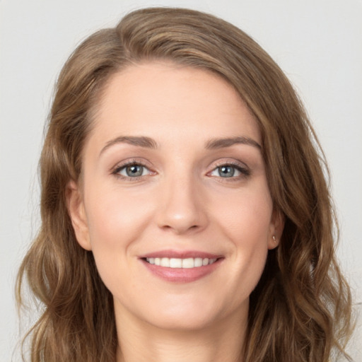 Joyful white young-adult female with long  brown hair and grey eyes