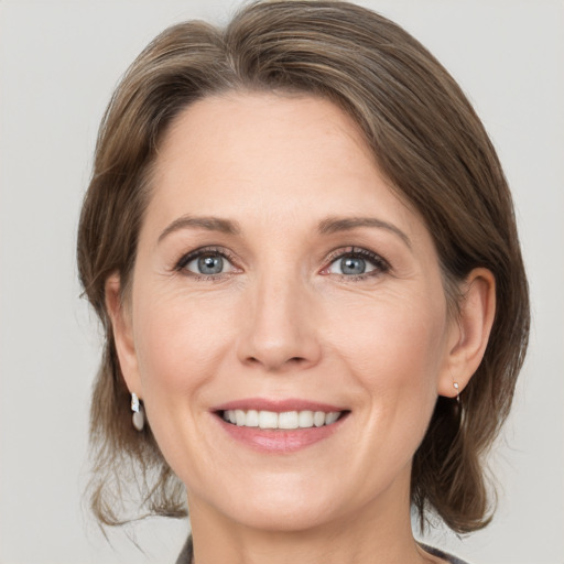 Joyful white adult female with medium  brown hair and grey eyes