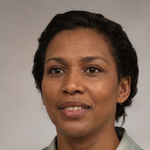Joyful black adult female with short  black hair and brown eyes