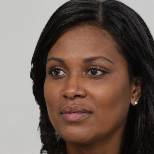 Joyful black young-adult female with long  black hair and brown eyes