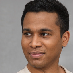 Joyful latino young-adult male with short  black hair and brown eyes