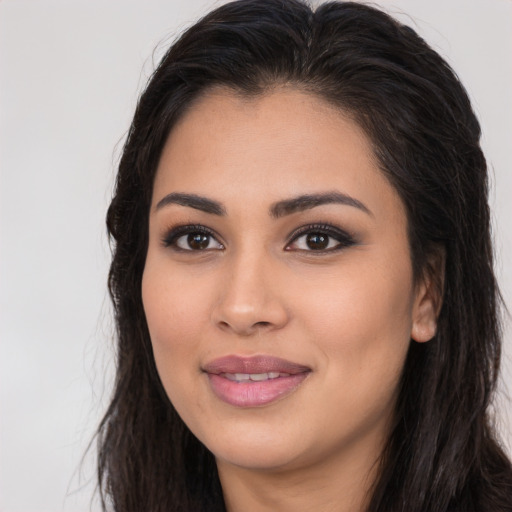 Joyful latino young-adult female with long  brown hair and brown eyes