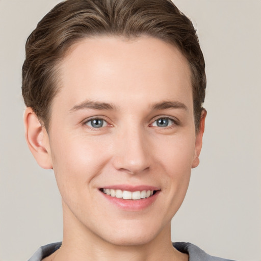 Joyful white young-adult female with short  brown hair and grey eyes