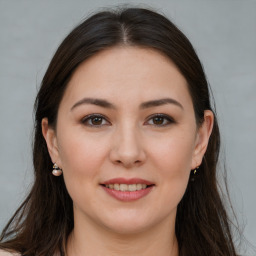 Joyful white young-adult female with long  brown hair and brown eyes