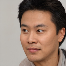 Joyful asian young-adult male with short  black hair and brown eyes