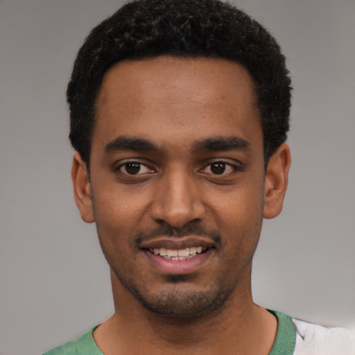 Joyful black young-adult male with short  black hair and brown eyes