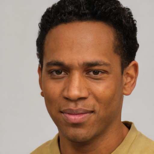 Joyful black young-adult male with short  brown hair and brown eyes