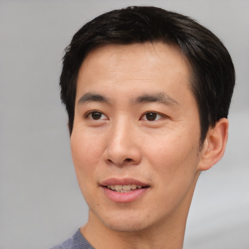 Joyful asian young-adult male with short  brown hair and brown eyes