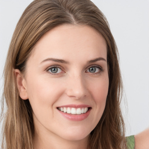 Joyful white young-adult female with long  brown hair and green eyes