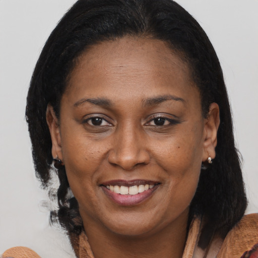 Joyful black adult female with medium  brown hair and brown eyes
