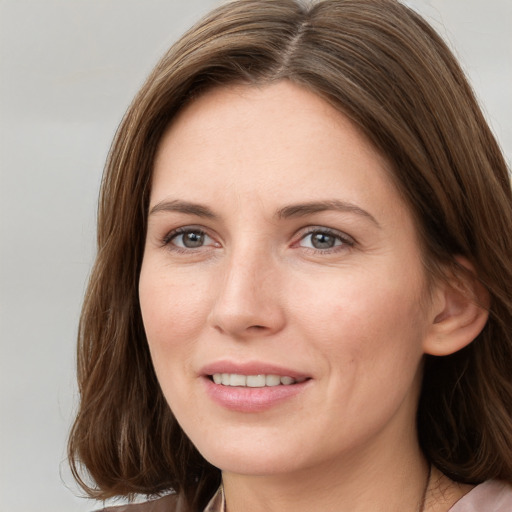 Joyful white young-adult female with medium  brown hair and grey eyes