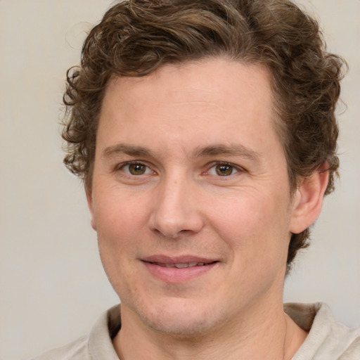 Joyful white young-adult male with short  brown hair and green eyes