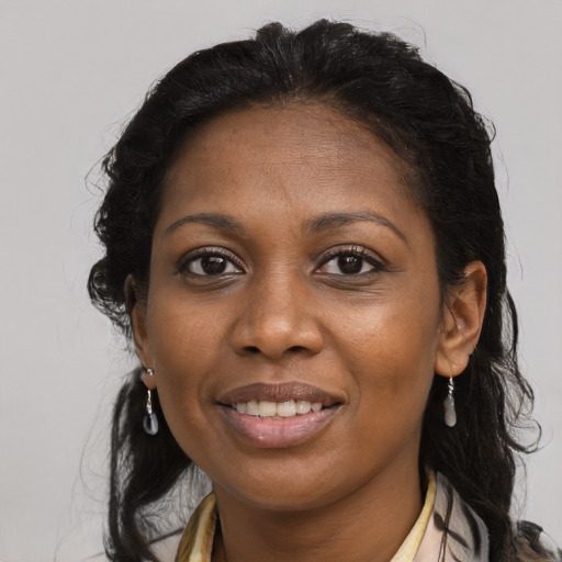 Joyful black young-adult female with long  brown hair and brown eyes
