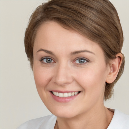 Joyful white young-adult female with medium  brown hair and grey eyes