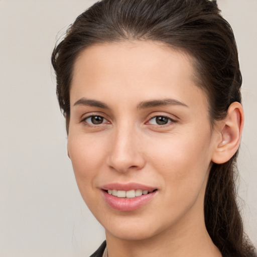 Joyful white young-adult female with long  brown hair and brown eyes