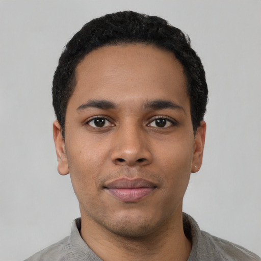 Joyful black young-adult male with short  black hair and brown eyes