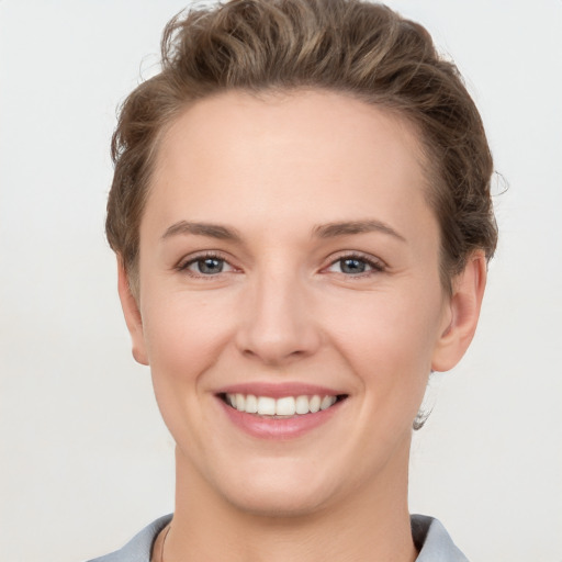 Joyful white young-adult female with short  brown hair and grey eyes