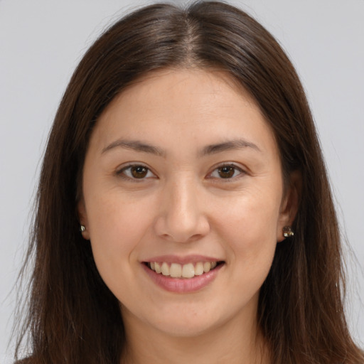 Joyful white young-adult female with long  brown hair and brown eyes