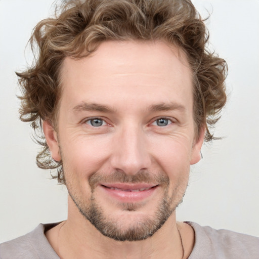 Joyful white young-adult male with short  brown hair and blue eyes