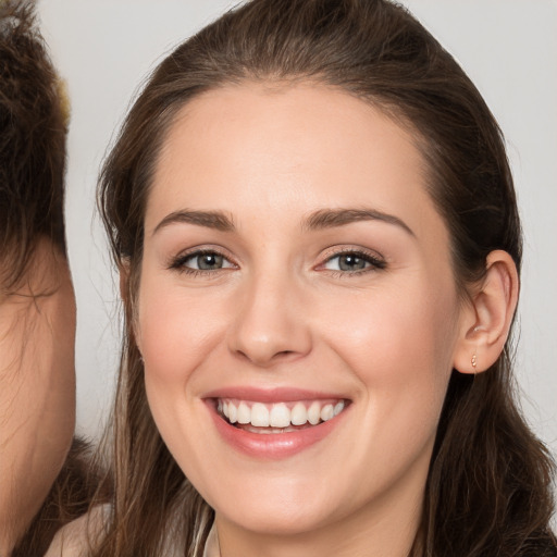 Joyful white young-adult female with long  brown hair and brown eyes