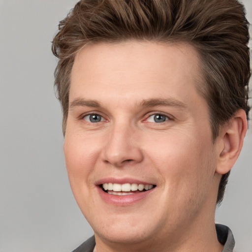 Joyful white adult male with short  brown hair and grey eyes