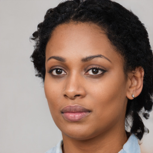 Joyful black young-adult female with medium  black hair and brown eyes