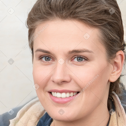 Joyful white young-adult female with long  brown hair and blue eyes