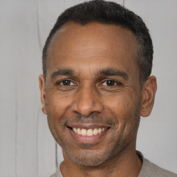 Joyful latino adult male with short  black hair and brown eyes