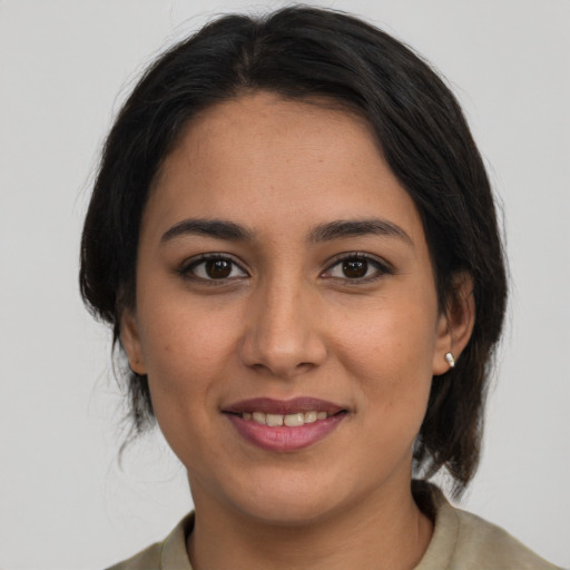 Joyful latino young-adult female with medium  brown hair and brown eyes