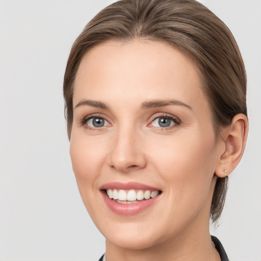 Joyful white young-adult female with medium  brown hair and grey eyes