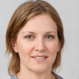 Joyful white adult female with medium  brown hair and grey eyes