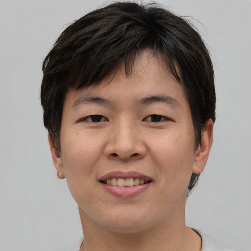 Joyful asian young-adult female with short  brown hair and brown eyes