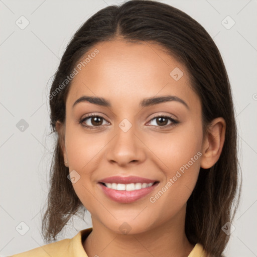 Joyful latino young-adult female with long  brown hair and brown eyes