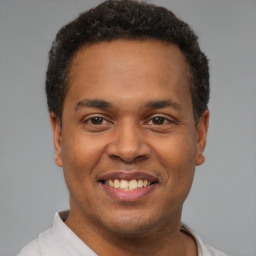 Joyful latino young-adult male with short  brown hair and brown eyes