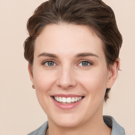 Joyful white young-adult female with short  brown hair and grey eyes