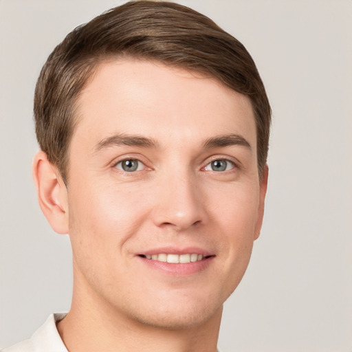 Joyful white young-adult male with short  brown hair and grey eyes