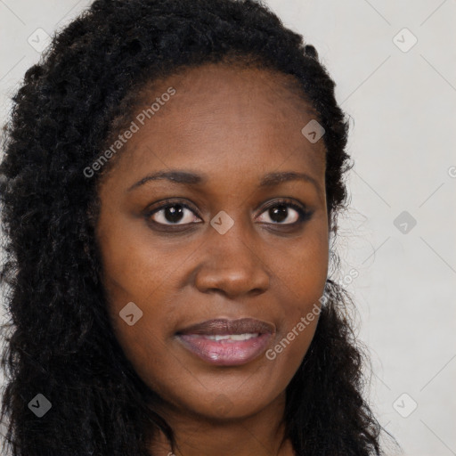 Joyful black young-adult female with long  brown hair and brown eyes