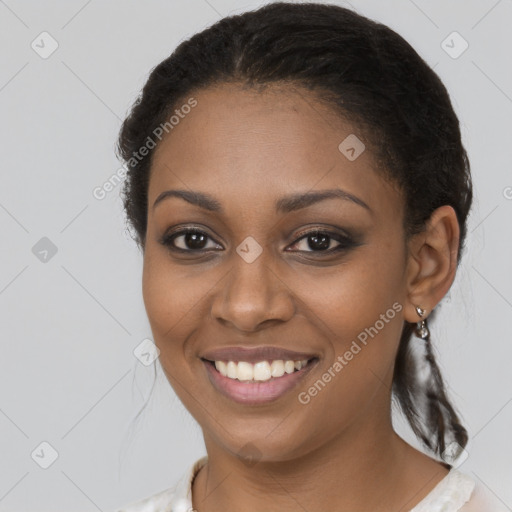 Joyful black young-adult female with long  brown hair and brown eyes