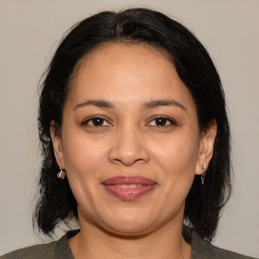 Joyful latino adult female with medium  brown hair and brown eyes