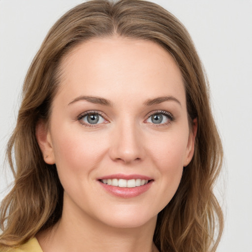 Joyful white young-adult female with long  brown hair and blue eyes