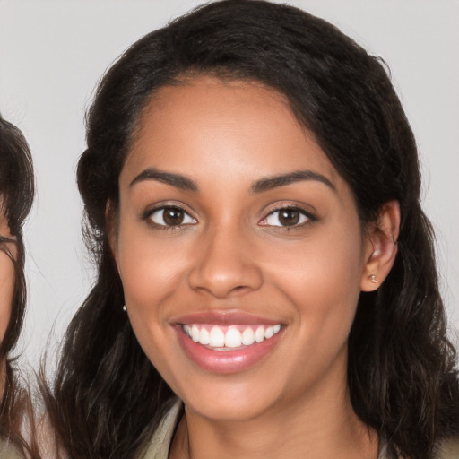 Joyful latino young-adult female with long  brown hair and brown eyes